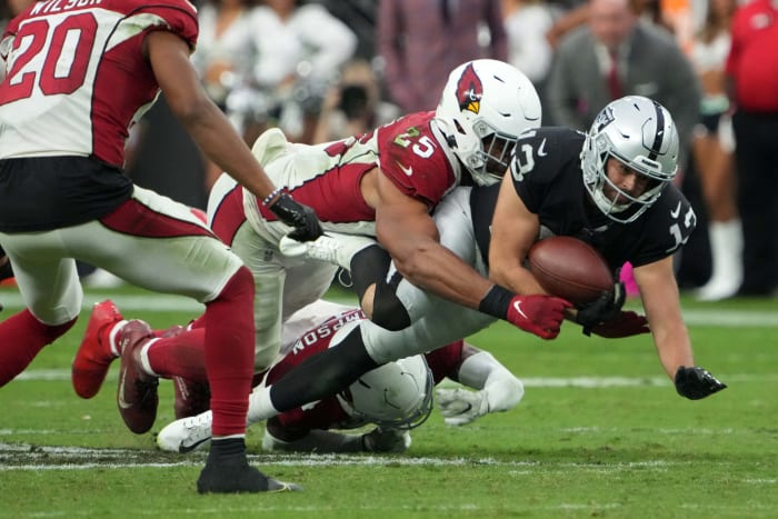 Hunter Renfrow loses the ball as he's tackled by Cardinals defenders